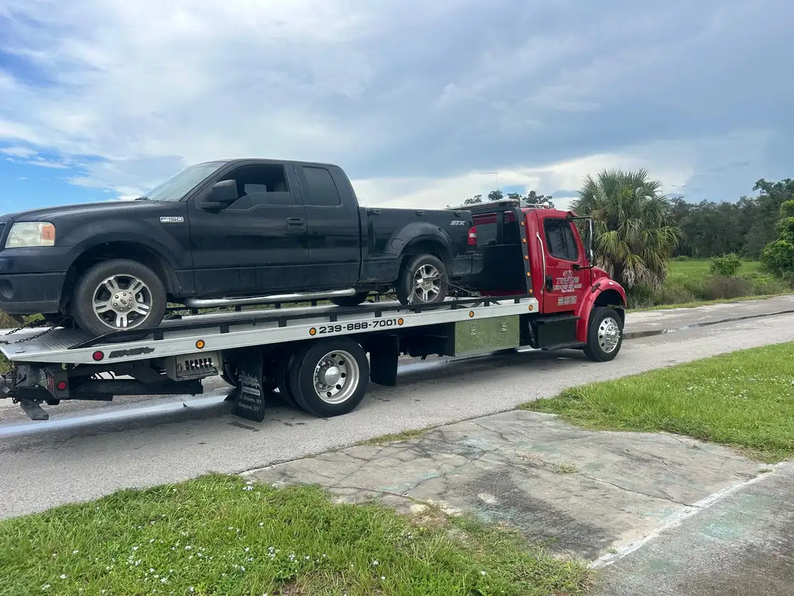Old black pickup loaded on the flatbed